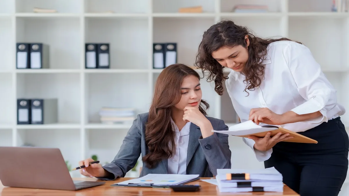 Bookkeeper for business reviewing financial records with a colleague